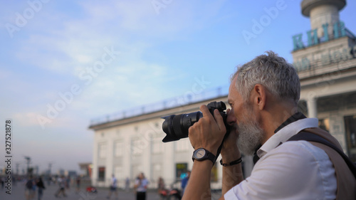 Fotografía Adult Professional Photographer Looks Into The Viewfinder To Find The Best View Of The City For The Shot