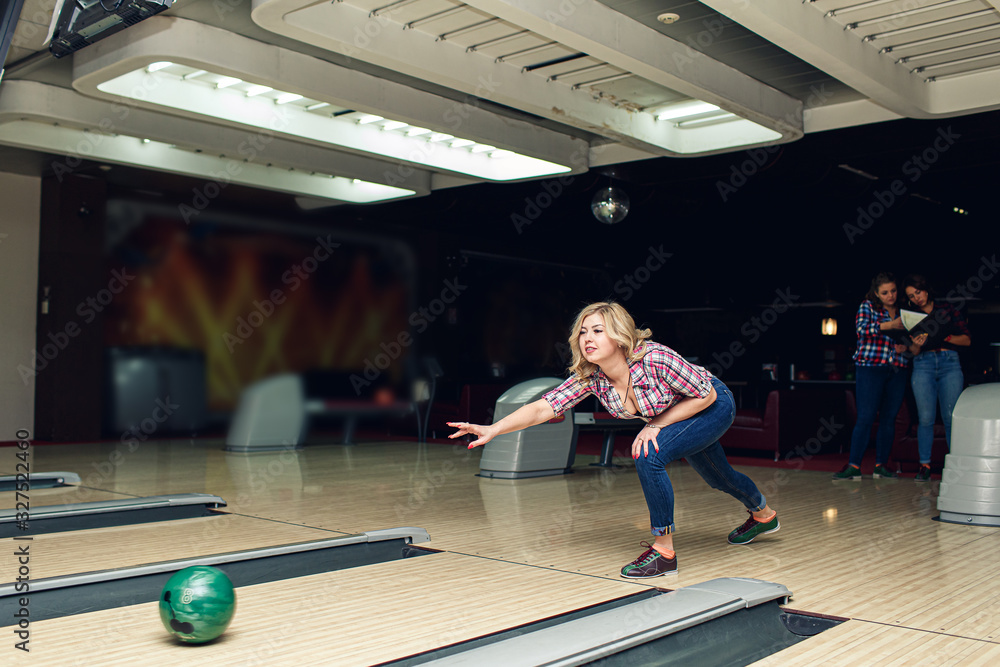 beautiful blonde girl plays bowling in club