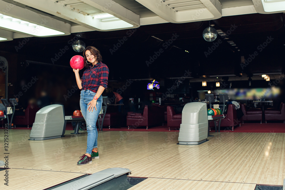 Fototapeta premium beautiful girl plays bowling in bowling club