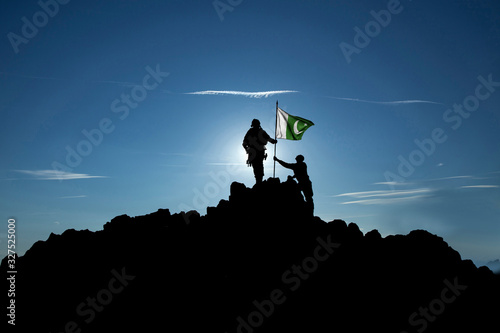 Foto Two soldiers raise the Pakistani flag