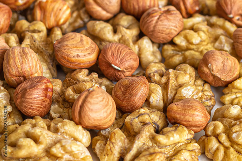 Background of a mixture of peeled hazelnuts and walnuts close-up