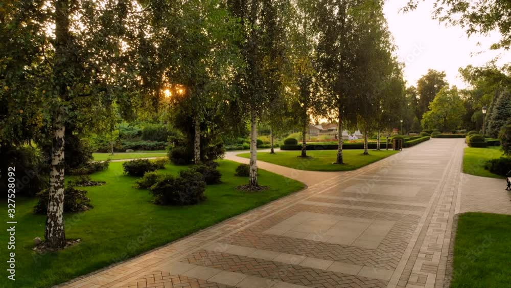 Cobblestone pathway in a park. Morning sunshine through park trees. Cobblestone pathway in a park. Morning sunshine through park trees.