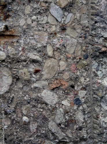 Ruined old concrete fence with the addition of stone and broken granite.