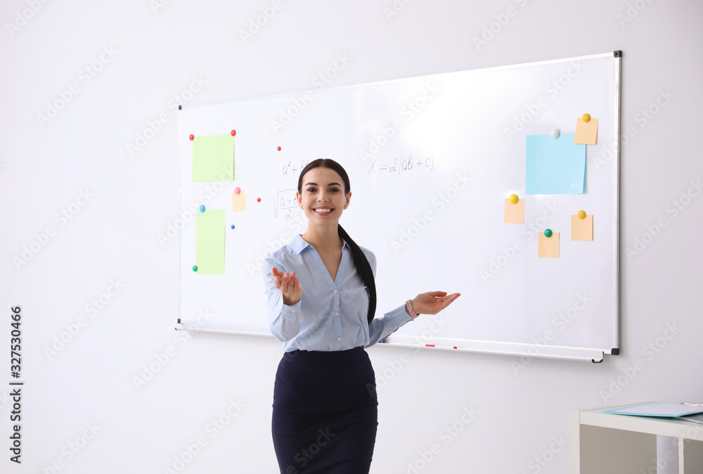 Fototapeta premium Young teacher near whiteboard in modern classroom