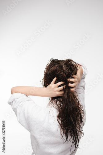 back view of young woman touching wet clean hair isolated on white