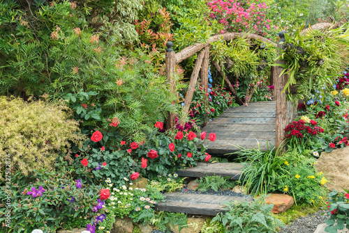 Old wooden bridge in beautiful flower garden in springtime season