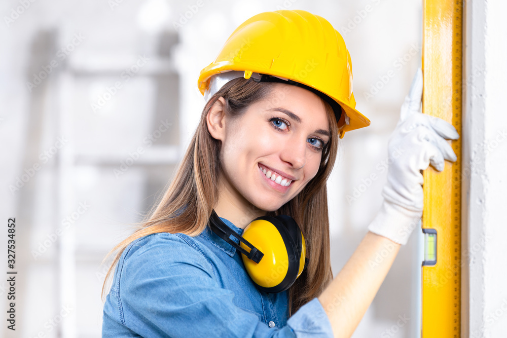 Attractive young female builder checking level Attractive young female builder checking level