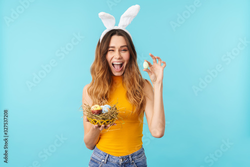 Photography Portrait of young woman holding basket with painted easter eggs