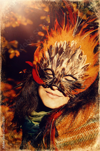 Young woman with a colorful feather face mask.