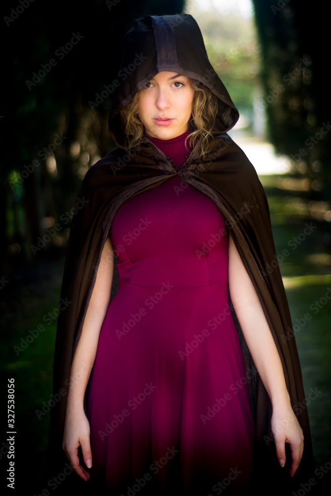 Beautiful woman with cape on a path in the woods Beautiful woman with cape on a path in the woods