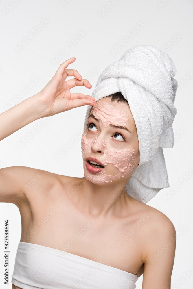 dissatisfied girl removing scrab mask from face while looking at camera isolated on white