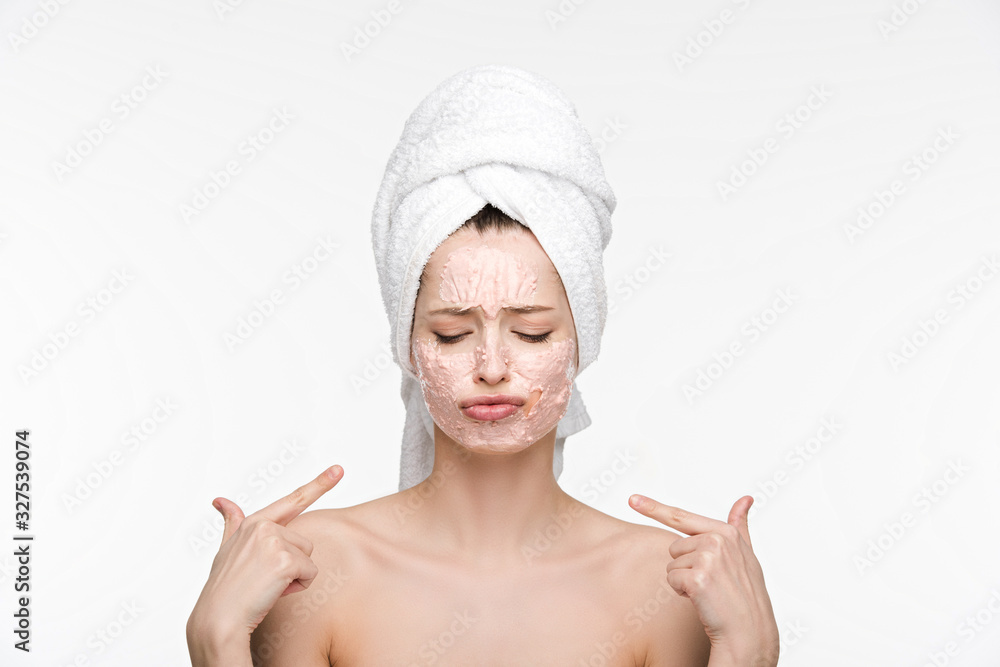 displeased pointing with fingers at peeling mask on face while standing with closed eyes isolated on white displeased pointing with fingers at peeling mask on face while standing with closed eyes isolated on white