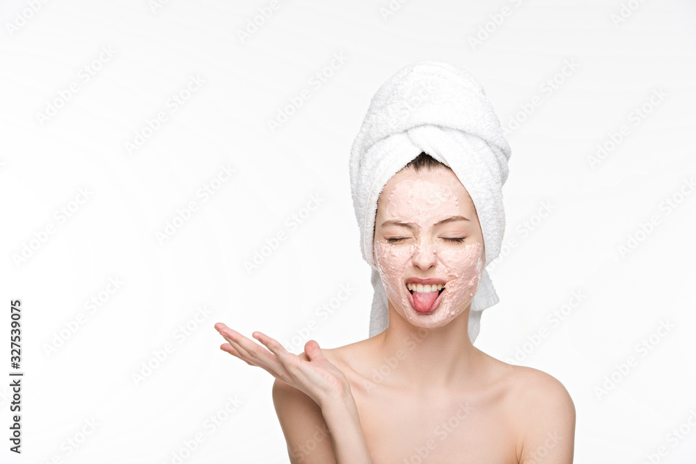 displeased girl with peeling mask on face sticking tongue out while standing with open arm and closed eyes isolated on white displeased girl with peeling mask on face sticking tongue out while standing with open arm and closed eyes isolated on white