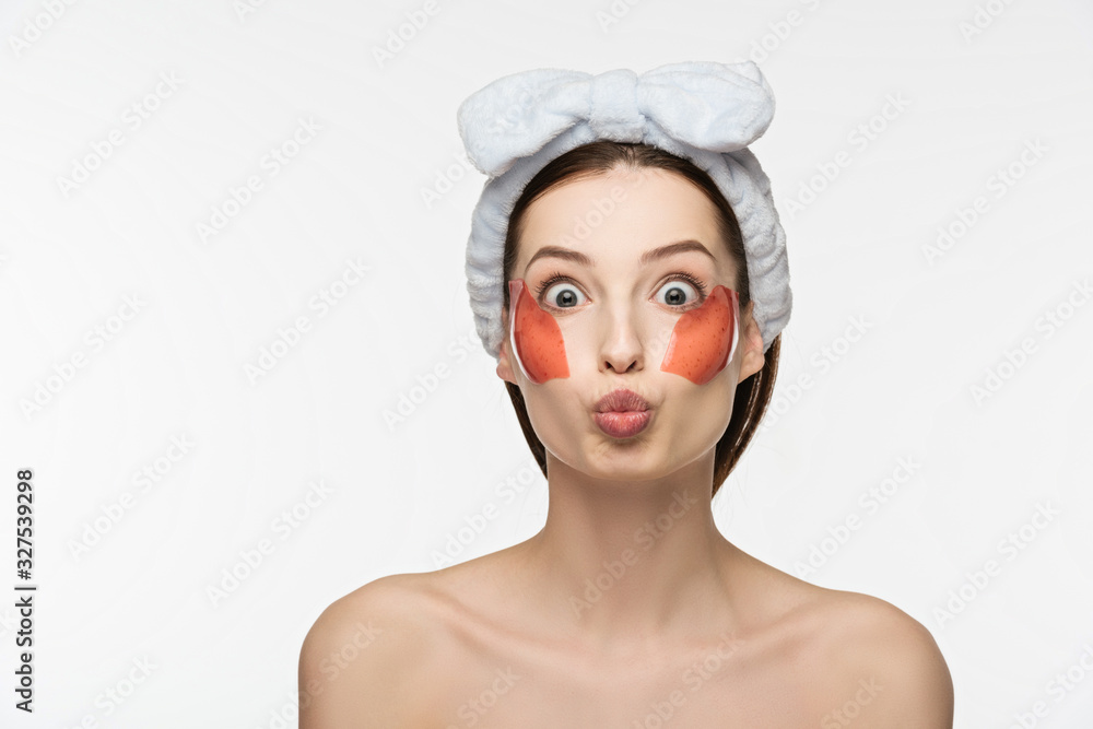 attractive girl with wide open eyes, duck face and collagen patches on face looking at camera isolated on white