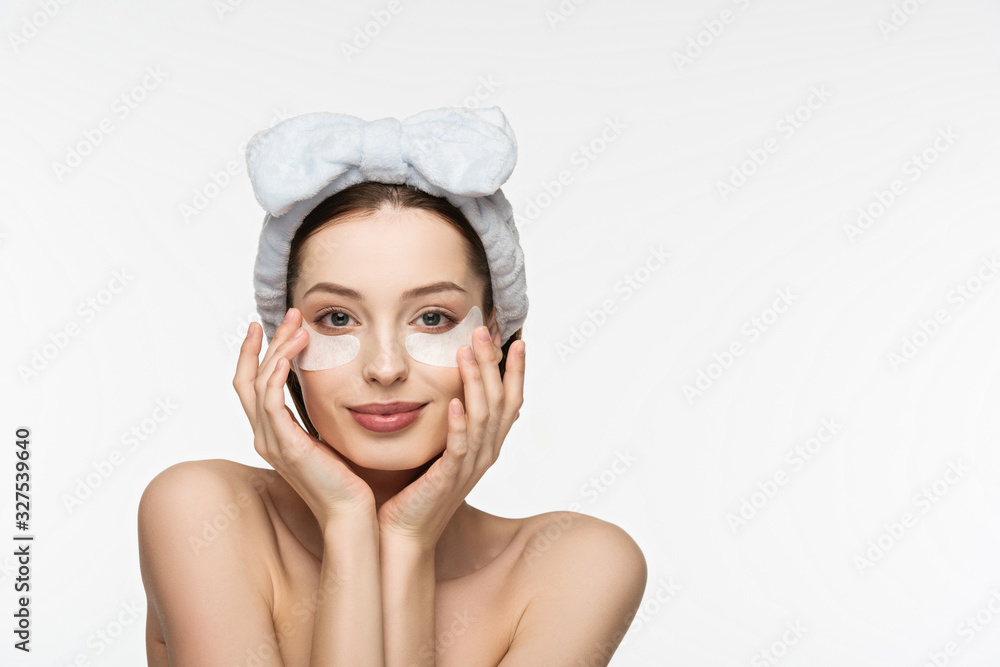 happy girl with eye patches touching face while looking at camera isolated on white happy girl with eye patches touching face while looking at camera isolated on white