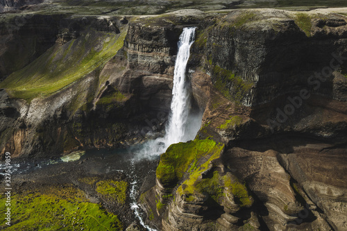 Aerial view of Haifoss big waterfall in south Iceland. Black high rocks  green hills and nobody around. Sunny summer weather.