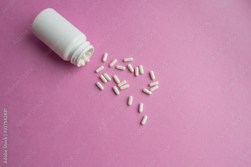 White and yellow pills on a pink background. Dosage of medication. Assorted pills in the shape of a heart. oral contraceptives. Cardiology White and yellow pills on a pink background. Dosage of medication. Assorted pills in the shape of a heart. oral contraceptives. Cardiology