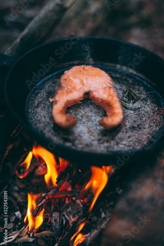 A piece of salmon in a pan over a fire. Cooking in nature. Grilled fish.