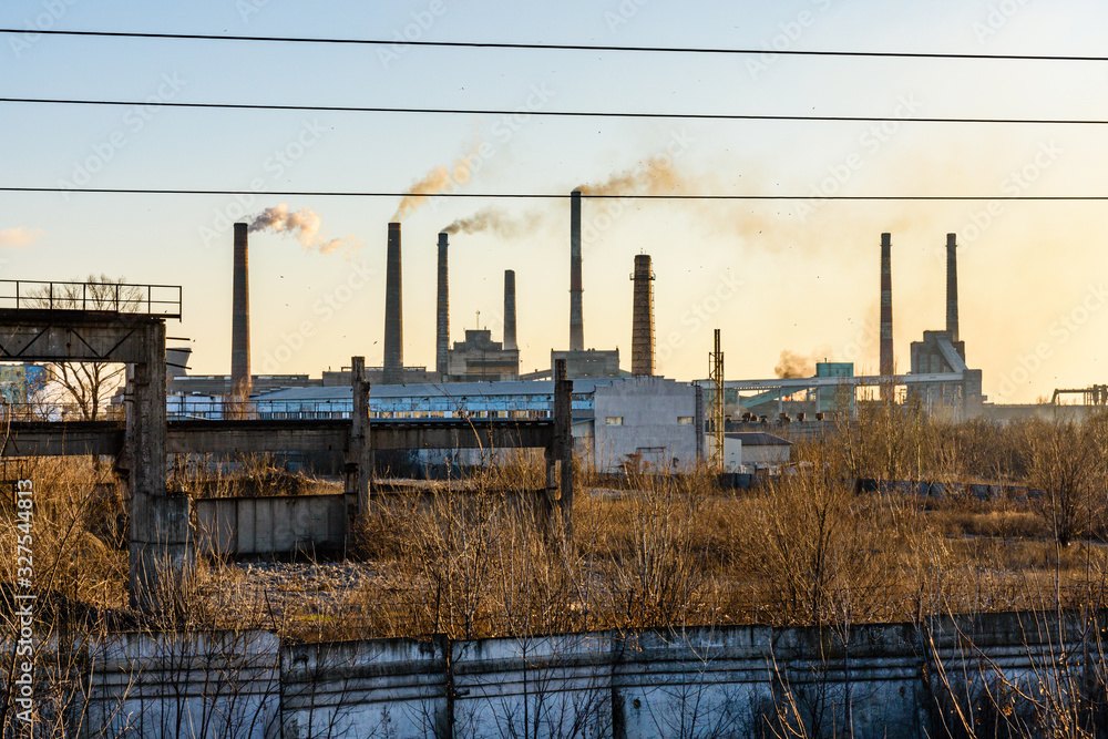 View on smoke pipes of the factory at sunset View on smoke pipes of the factory at sunset