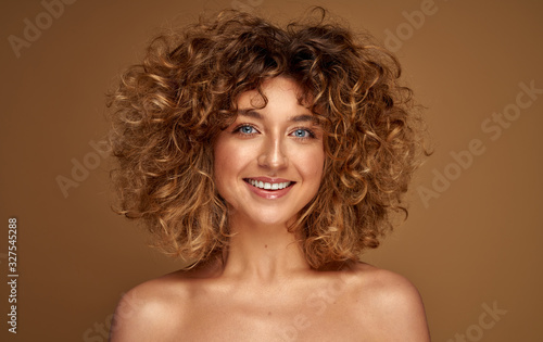 Portrait of cheerful young woman with curly hair