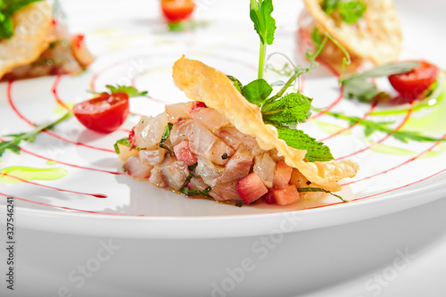 Foto Seabass tartare with fresh strawberry mint and chips