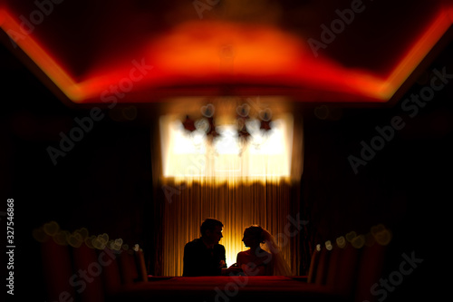 silhouette man and woman on the romantic date in evening cafe. couple in love .  bride and groom tenderness looks each other indoor night portrait with lamp. love story background.  © mihail_pustovit