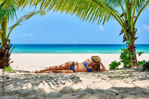 Woman at beach under palm tree photo