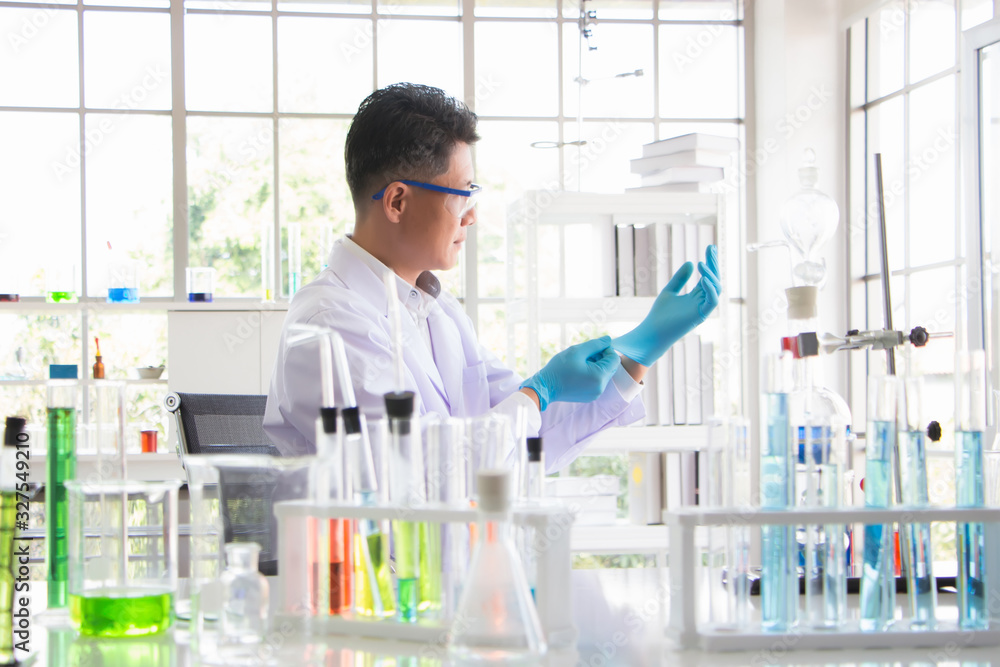 Asian Thai researchers are wearing rubber gloves to prepare for the production of the Covid-19 antiretroviral drug. The table is full of drugs, chemicals, test tubes, and devices use in the experiment Asian Thai researchers are wearing rubber gloves to prepare for the production of the Covid-19 antiretroviral drug. The table is full of drugs, chemicals, test tubes, and devices use in the experiment