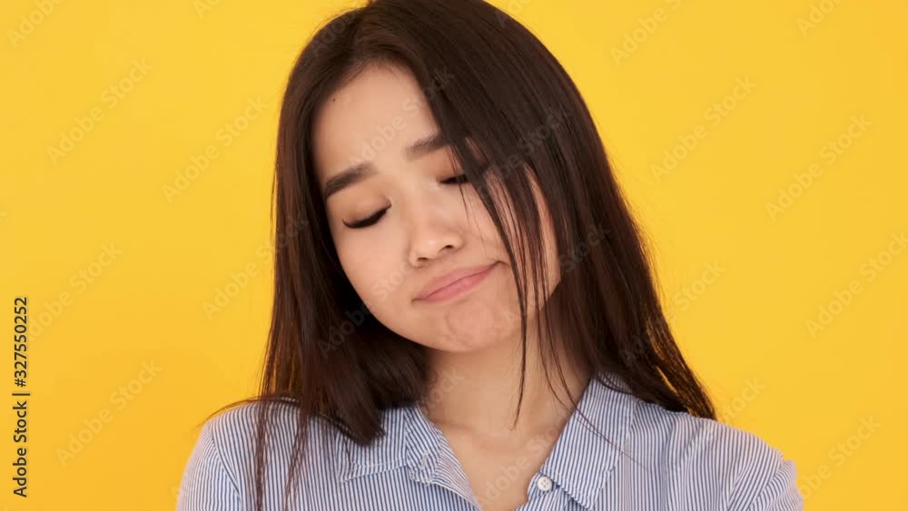 Girl Asian on yellow background close-up offended dissatisfied. wants to cry Girl Asian on yellow background close-up offended dissatisfied. wants to cry