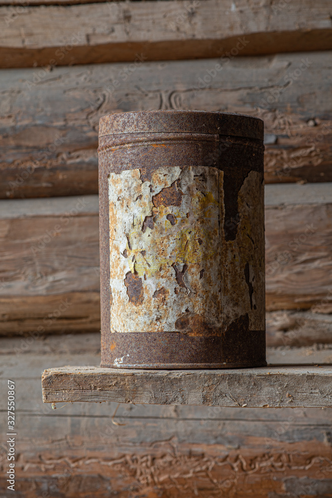 old rusty can against a timbered wall old rusty can against a timbered wall