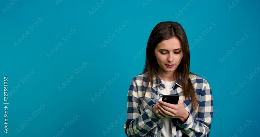 girl looking away and typing on smartphone with smile girl looking away and typing on smartphone with smile