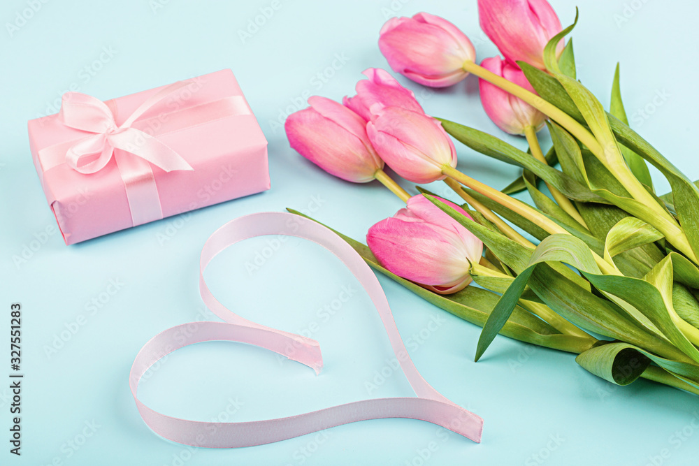 tulips and gift box on blue. Background for womens day, 8 March Valentine's day, 14 february. Flat lay style, top view, mockup, template, overhead. Greeting card