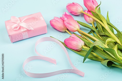 tulips and gift box on blue. Background for womens day, 8 March Valentine's day, 14 february. Flat lay style, top view, mockup, template, overhead. Greeting card