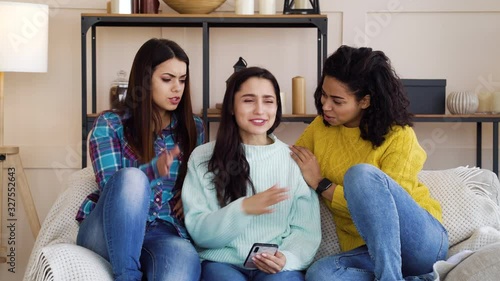 Caring girls reassuring their angry friend using smartphone at home