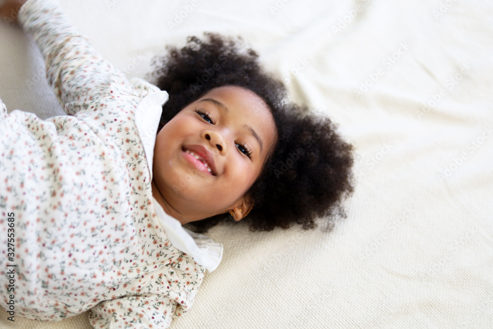 Beautiful African american girl kid smile portrait in bedroom at home. Beautiful African american girl kid smile portrait in bedroom at home.