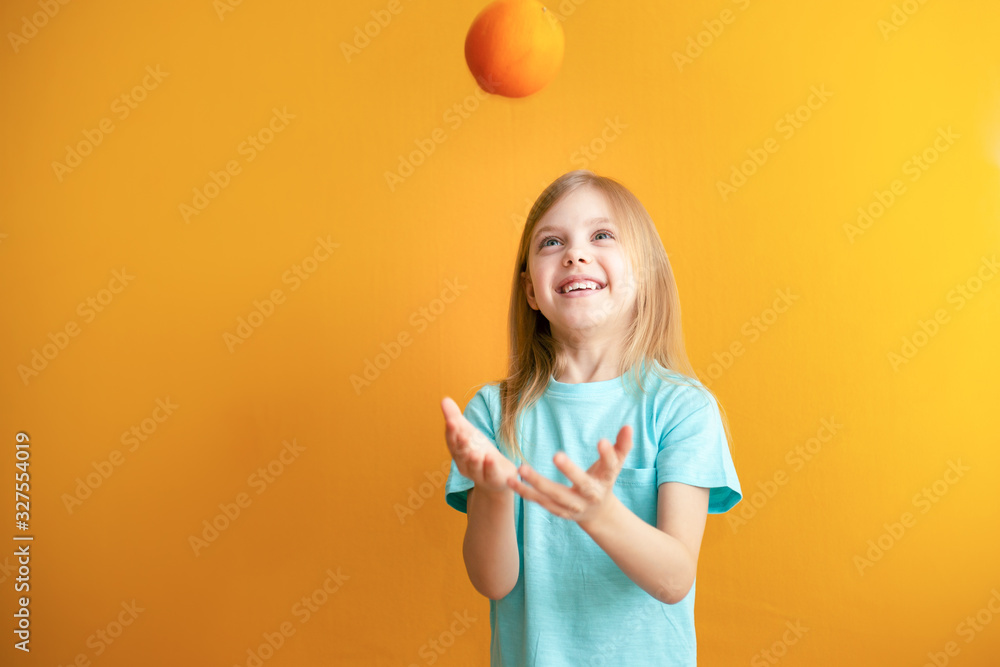Cute baby on an orange background, 6-8 years old, baby girl throws appelsyn up Cute baby on an orange background, 6-8 years old, baby girl throws appelsyn up