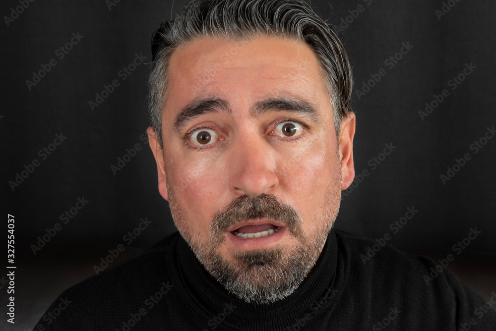 Portrait of shocked gasping man on black background. Portrait of shocked gasping man on black background.