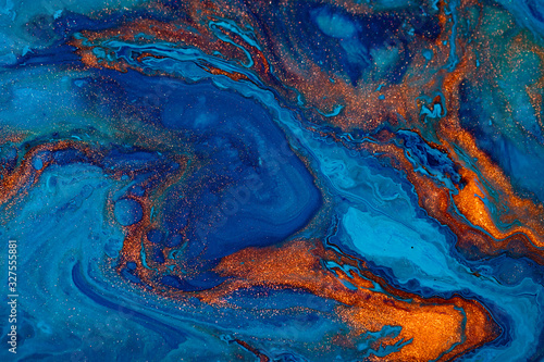 Fluid art texture. Background with abstract swirling paint effect. Liquid acrylic picture with flows and splashes. Mixed paints for posters or wallpapers. Blue, orange and golden overflowing colors