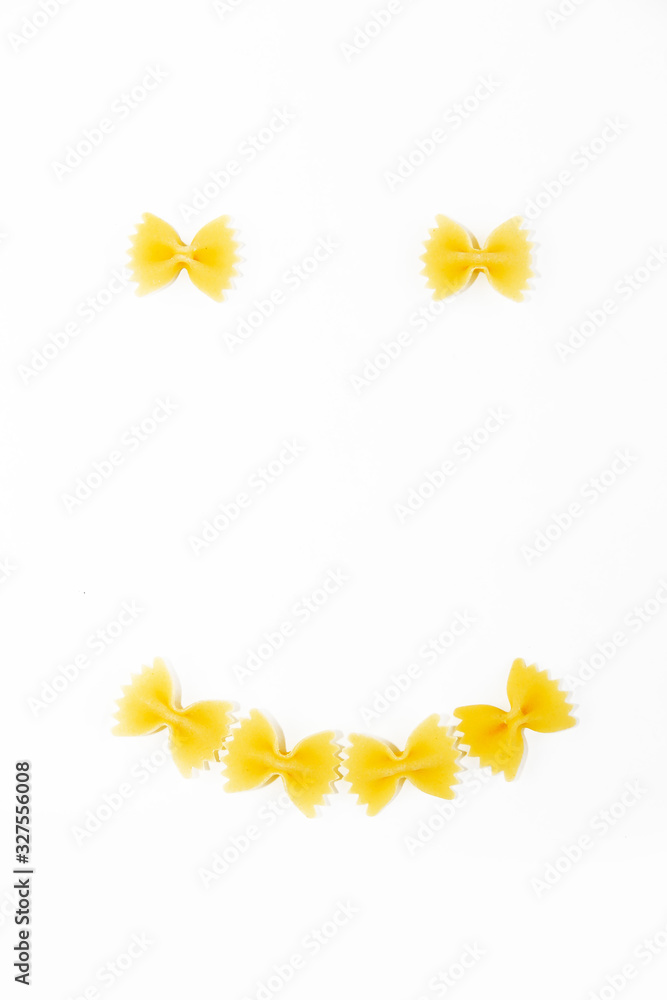 natural yellow macoroni farfalle butterfly in the form of a smile on a white background natural yellow macoroni farfalle butterfly in the form of a smile on a white background