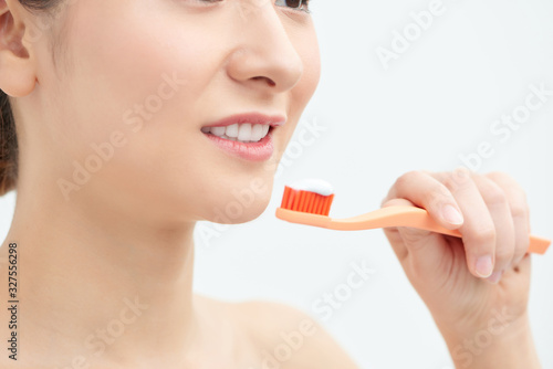 A girl is brushing her teeth with a toothbrush