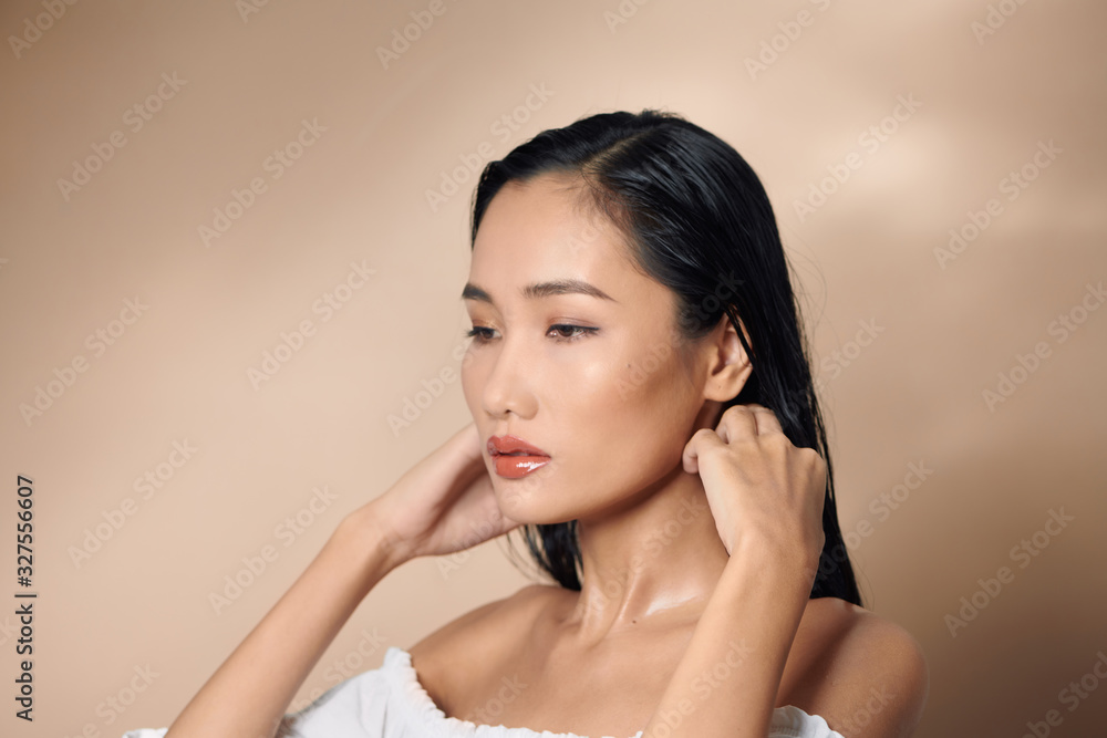 Fashion studio photo of gorgeous sexy woman with luxurious dark hair on beige backgroung Fashion studio photo of gorgeous sexy woman with luxurious dark hair on beige backgroung