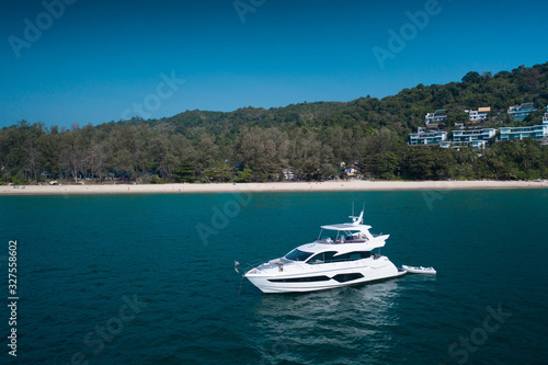 Aerial drone view of luxury white yacht in the blue sea with beach in the background. Travel concept © stryjek