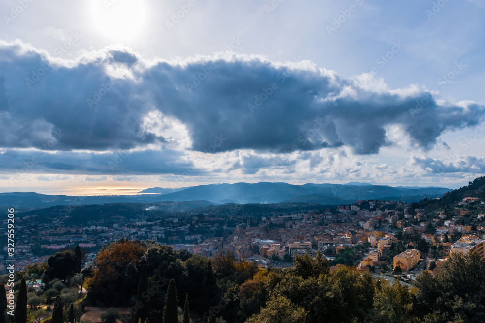 The panoramic view of a medieval French town in Côte d'Azur under the cloudy moody sky next to the Meditarrenean sea