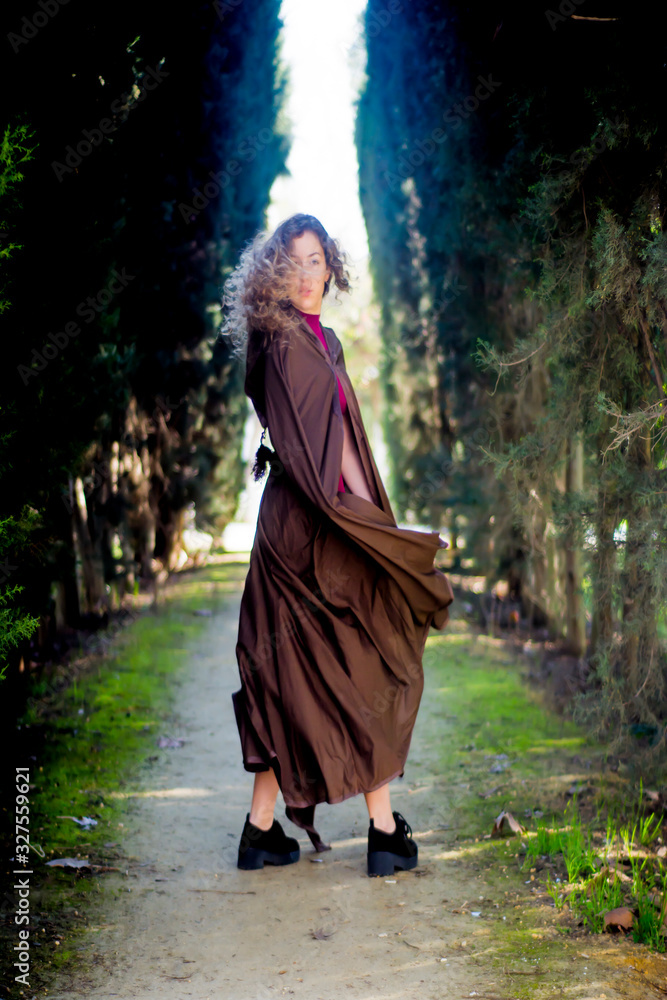Beautiful woman with cape on a path in the woods Beautiful woman with cape on a path in the woods
