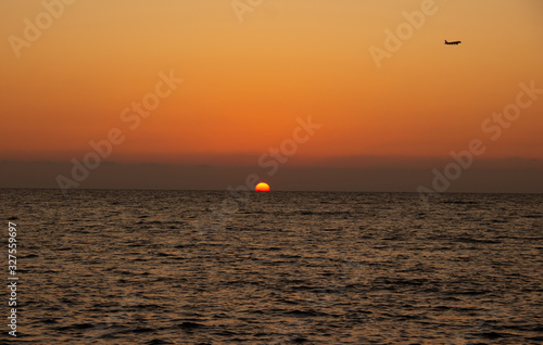 eautiful Sunny sunset on the sea. Amazing summer view on the beach.  blazing sunset landscape at black sea and orange sky above it with awesome sun golden reflection on calm waves.