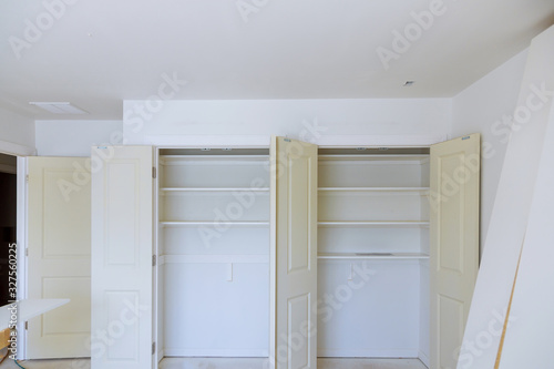 Interior of white shelf or clothing with many empty shelves with installation. © ungvar