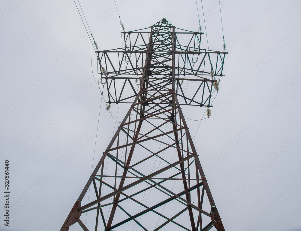 high-voltage tower stands against the blue sky