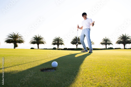 Professinal golf player on golf course. Pro golfer taking a shot