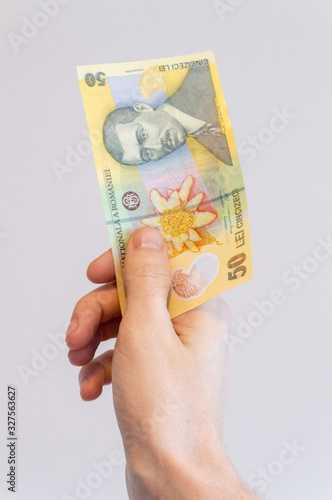 50 Romanian lei banknote in hand. Banknote with portrait of Aurel Vlaicu, pilot and airplane builder.