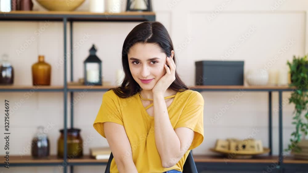 Shy girl smiling and looking away in living room Shy girl smiling and looking away in living room